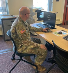 Military personnel using a computer in the DLP classroom.